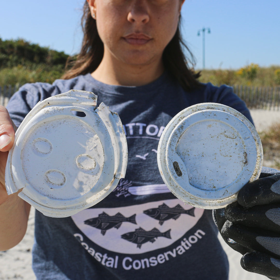 lady holding ocean plastic coffee cup lid
