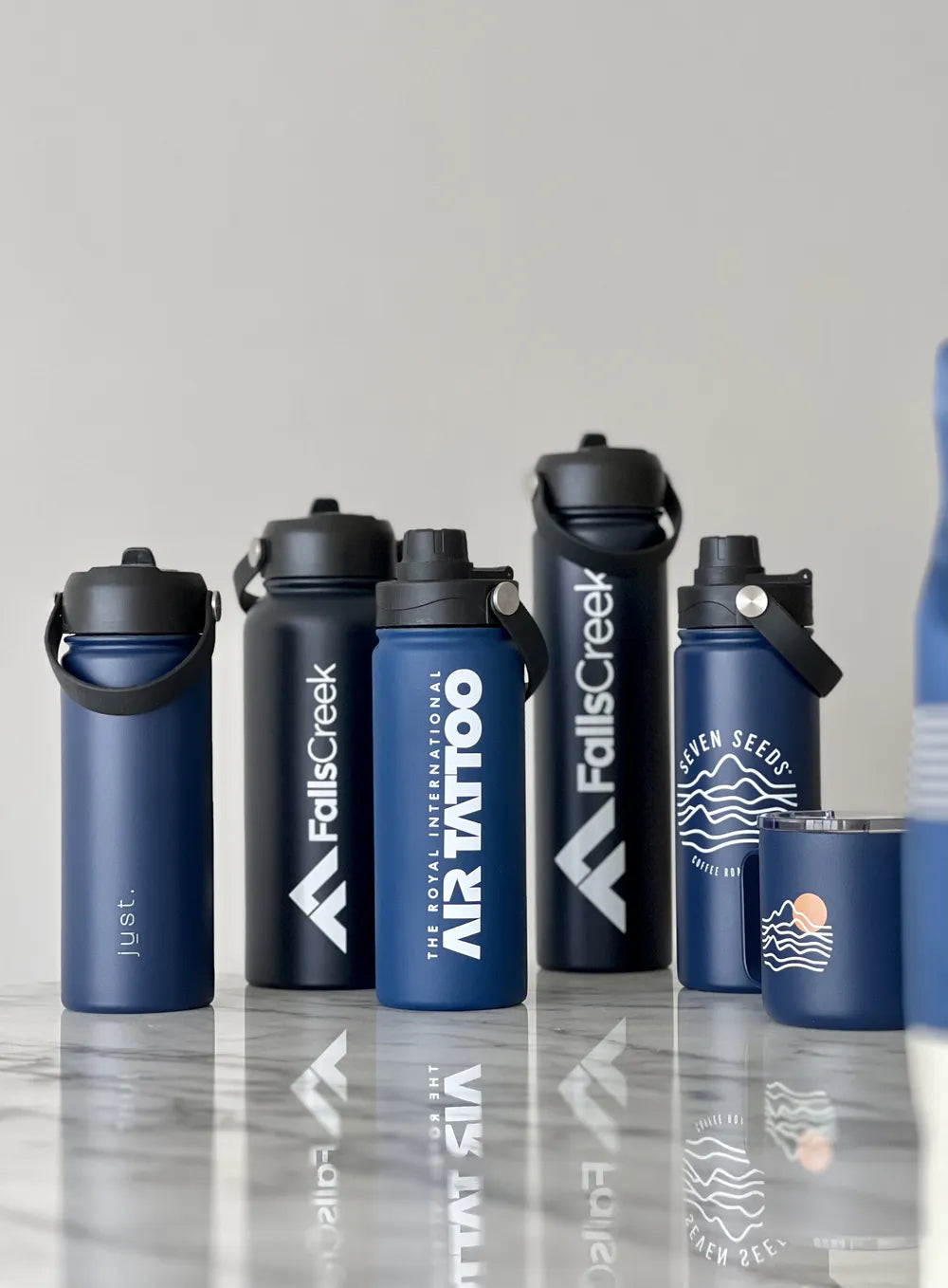 five custom branded water bottles on a marble table